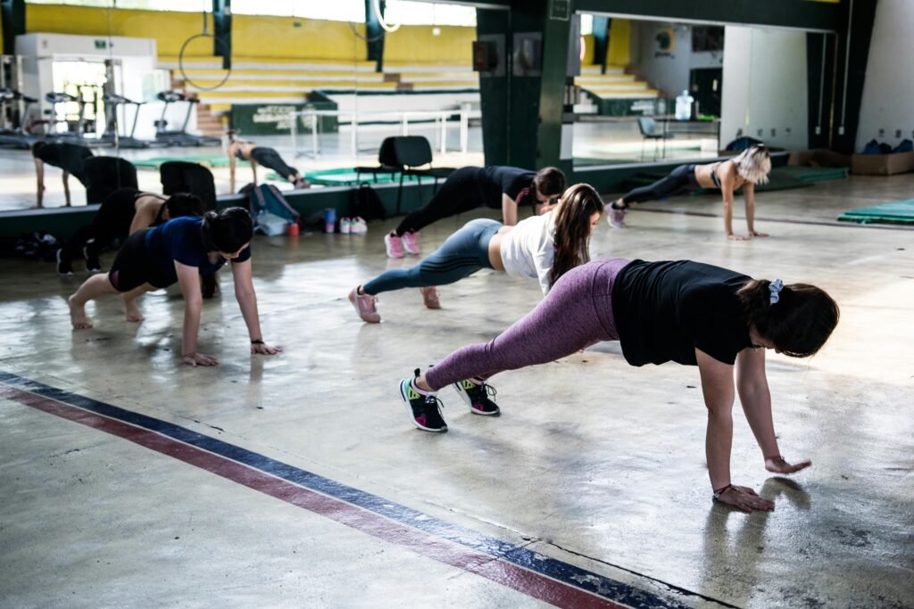 nutritions Group of women doing push-ups in a gym reflecting in a mirror.