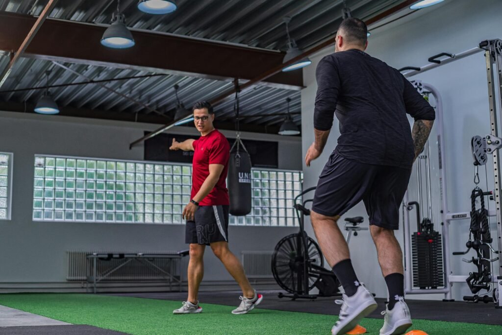 yoga Full body of muscular sportsman in activewear doing exercises with instructor in modern gym